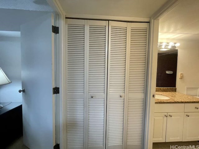 bathroom with a closet and vanity