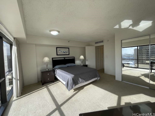 carpeted bedroom featuring visible vents and a textured ceiling