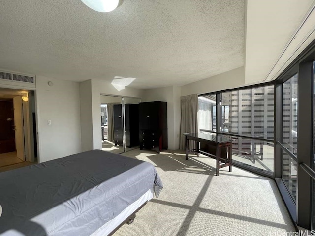 carpeted bedroom featuring visible vents and a textured ceiling