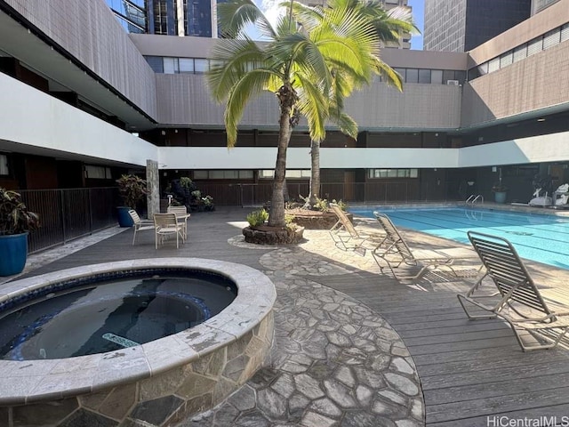 pool with a hot tub and a patio