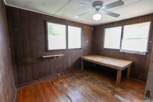 unfurnished bedroom featuring a sauna, multiple windows, wood walls, and hardwood / wood-style flooring