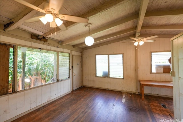 empty room featuring wood finished floors, vaulted ceiling with beams, ceiling fan, wood walls, and wooden ceiling