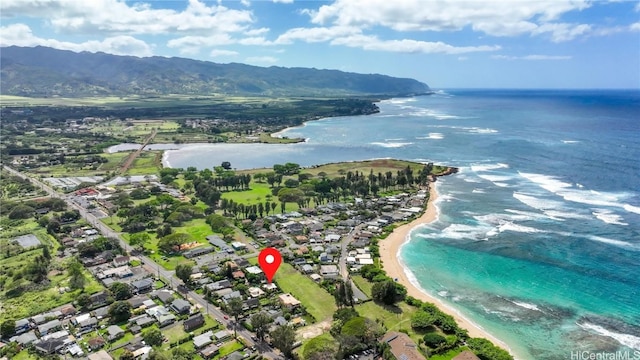 birds eye view of property with a water view and a beach view