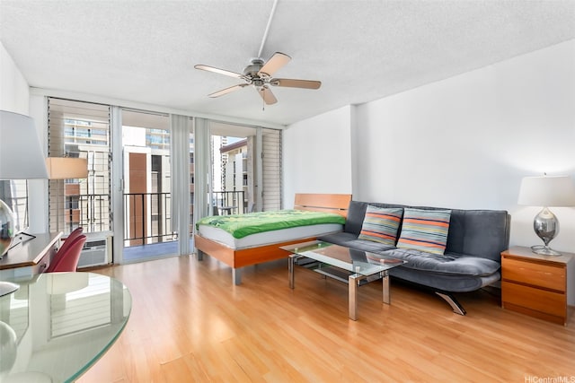 2345 Ala Wai Blvd Unit 1003, Honolulu, HI 96815 - living room featuring light wood-style floors, ceiling fan, a textured ceiling, and a wall of windows