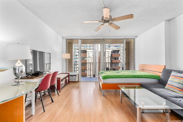 2345 Ala Wai Blvd Unit 1003, Honolulu, HI 96815 - bedroom featuring light wood-style floors, access to outside, a textured ceiling, and floor to ceiling windows