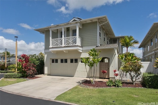 view of front of property featuring a front lawn, a balcony, a garage, and driveway