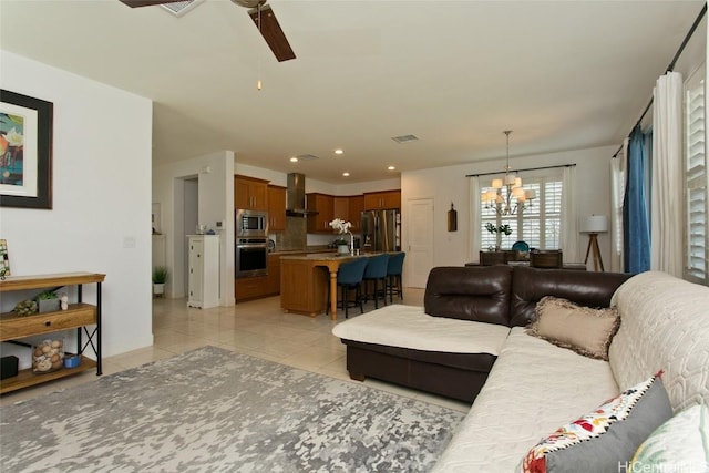 living area featuring recessed lighting, light tile patterned flooring, ceiling fan with notable chandelier, and visible vents