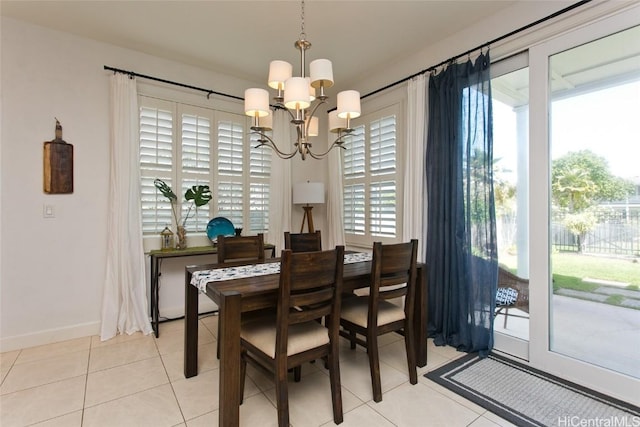 dining area with light tile patterned floors, a notable chandelier, and baseboards