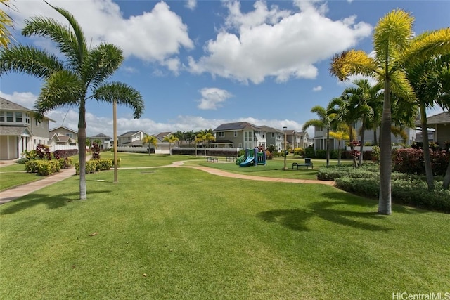 view of community featuring playground community, a residential view, and a yard