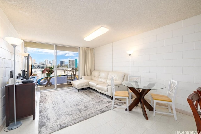 living room featuring light tile patterned floors, a textured ceiling, and floor to ceiling windows