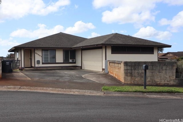 view of front of house featuring an attached garage, fence, driveway, and roof with shingles