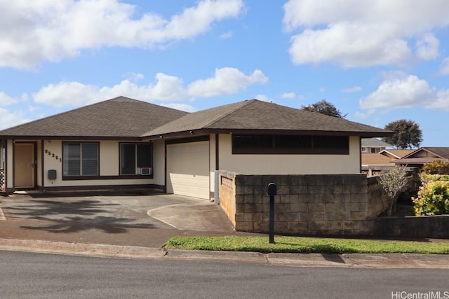 view of front facade with a garage, roof with shingles, and driveway