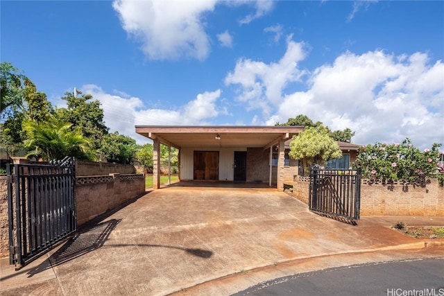 view of front of property featuring a carport, concrete driveway, a gate, and fence