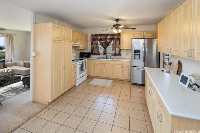 kitchen with light brown cabinets, black microwave, light countertops, stainless steel refrigerator with ice dispenser, and white range with electric stovetop