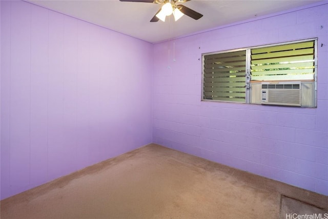 spare room with cooling unit, concrete block wall, and ceiling fan