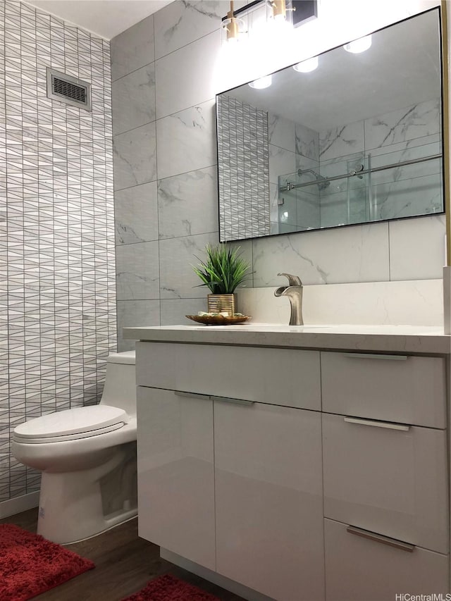 1519 Nuuanu Ave Unit 142, Honolulu, HI 96817 - full bath featuring wood finished floors, vanity, tile walls, toilet, and a walk in shower