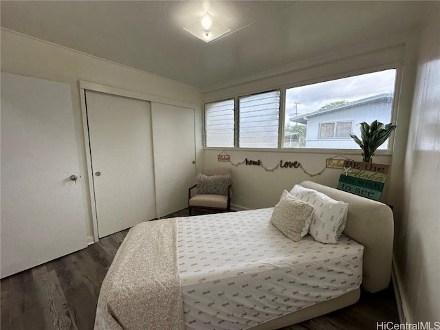 bedroom with dark wood finished floors and a closet