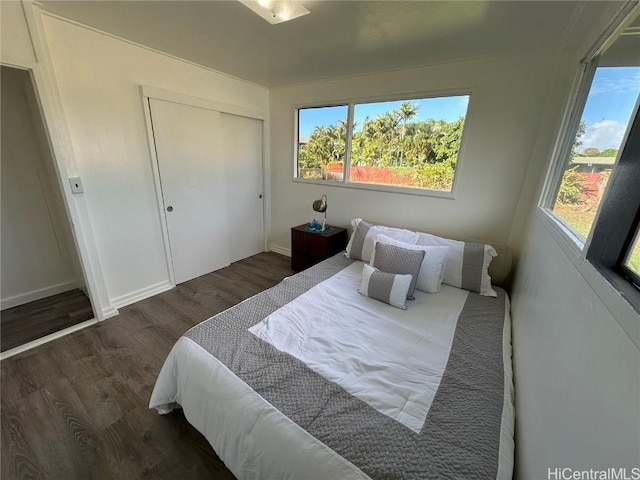 bedroom with a closet, baseboards, and wood finished floors