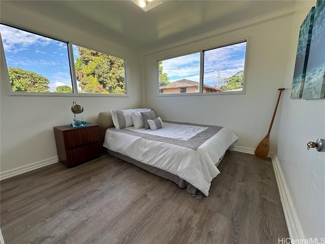 bedroom with baseboards and wood finished floors