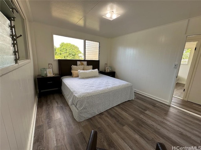 bedroom with baseboards and dark wood-style flooring