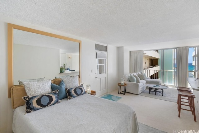 carpeted bedroom with a textured ceiling and access to outside