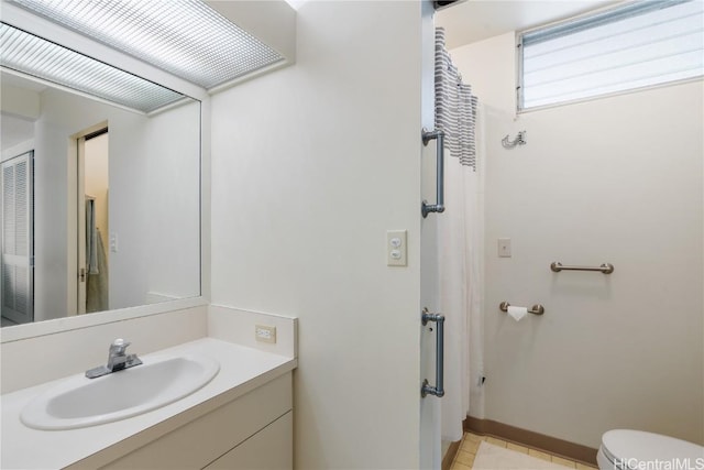 full bath with vanity, toilet, and baseboards