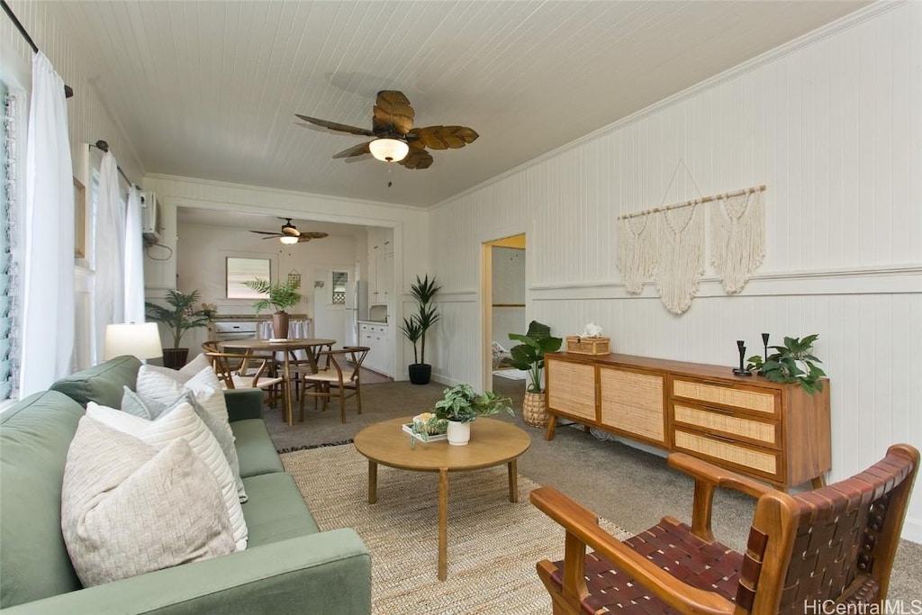 living room featuring a ceiling fan, carpet flooring, and crown molding