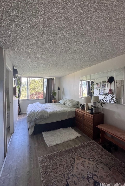 bedroom with wood finished floors and a textured ceiling