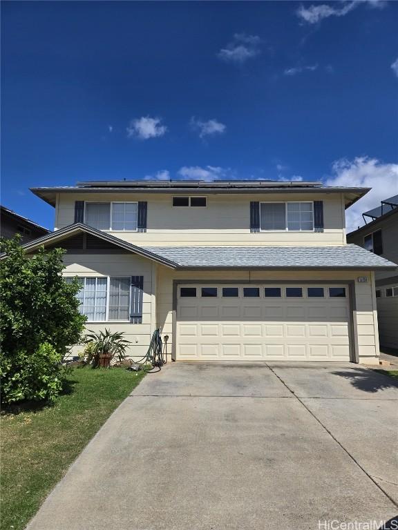 traditional-style house with solar panels, concrete driveway, and a garage