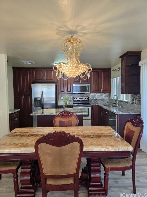 kitchen with a sink, a center island, tasteful backsplash, and stainless steel appliances