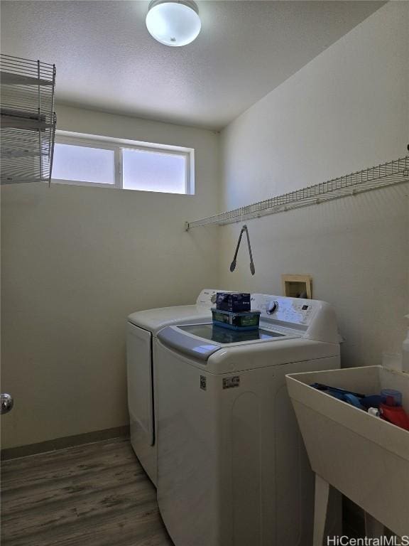 laundry area featuring laundry area, light wood-style flooring, separate washer and dryer, and baseboards