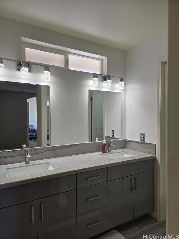 full bathroom featuring double vanity, wood finished floors, and a sink