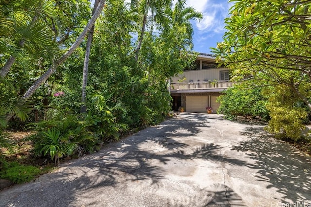 obstructed view of property featuring a garage and concrete driveway