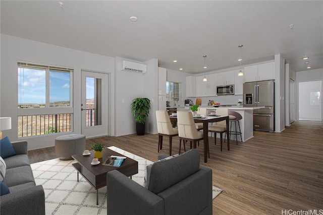 living room featuring recessed lighting, light wood-style floors, and a wall mounted AC