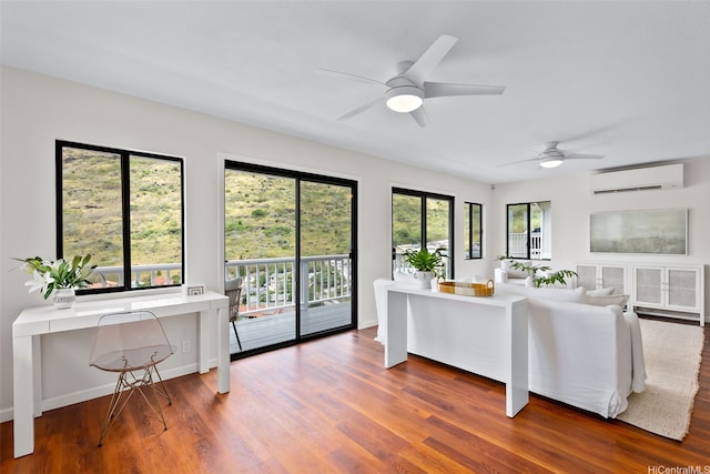 living area with ceiling fan, a wall unit AC, and wood finished floors