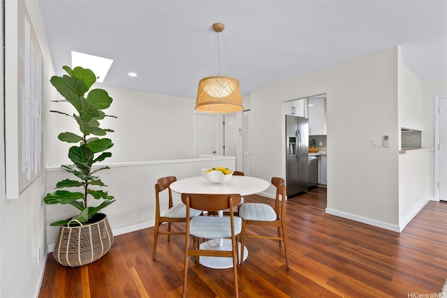 dining room featuring recessed lighting, a skylight, dark wood-style floors, and baseboards