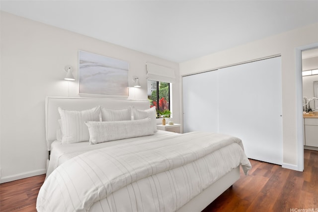 bedroom with a closet, baseboards, and wood finished floors