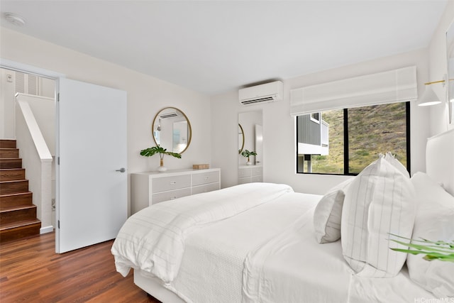 bedroom with an AC wall unit and dark wood-type flooring