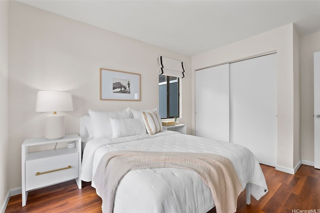 bedroom with baseboards, a closet, and wood finished floors