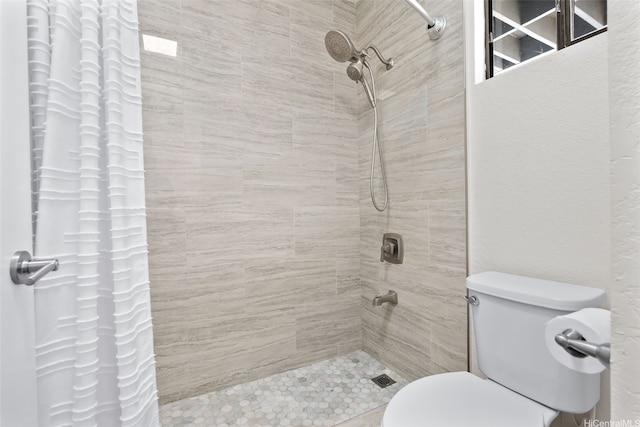 full bathroom with toilet and tiled shower