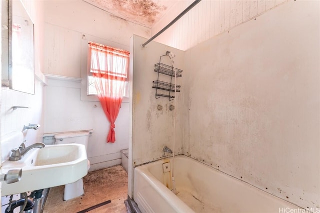 bathroom with washtub / shower combination and a sink