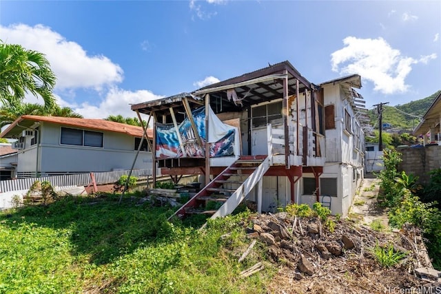 back of house featuring stairs and fence