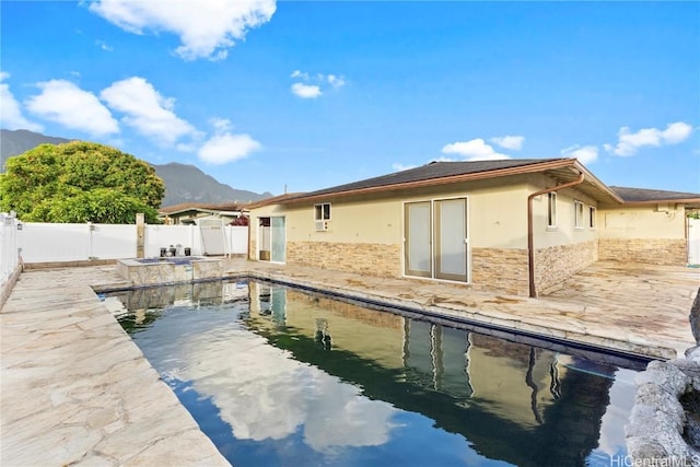 back of property featuring a fenced in pool, a fenced backyard, stucco siding, a patio area, and a mountain view