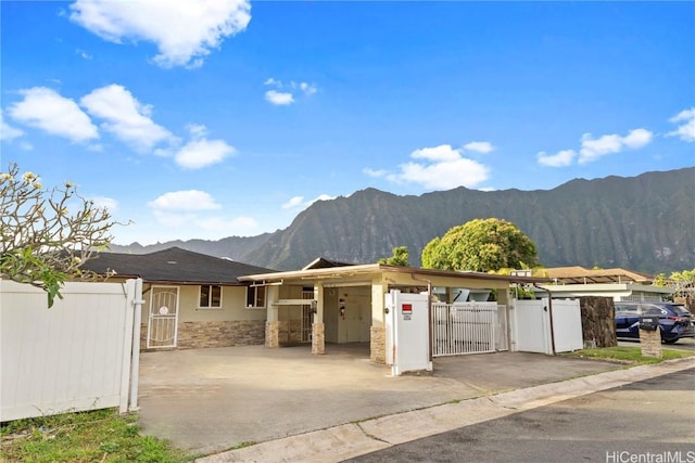 view of front of house featuring a gate, fence, driveway, stucco siding, and a mountain view