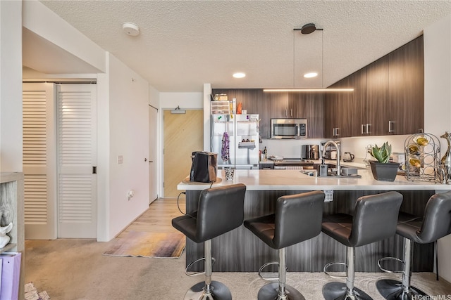 615 Keawe St Unit 1905, Honolulu, HI 96813 - kitchen featuring stainless steel appliances, a kitchen bar, light countertops, a peninsula, and pendant lighting