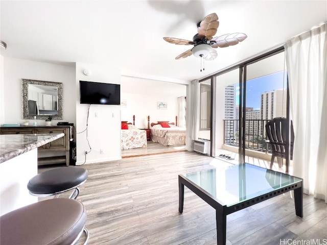 201 Ohua Ave Unit 1108, Honolulu, HI 96815 - living area featuring baseboards, ceiling fan, a wall mounted air conditioner, light wood-type flooring, and expansive windows