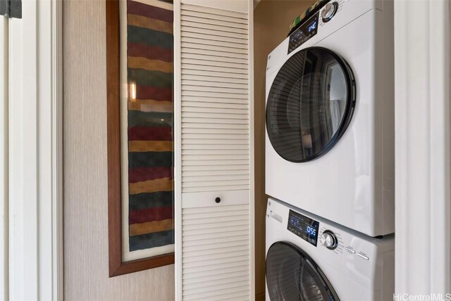 laundry room featuring stacked washer / dryer and laundry area