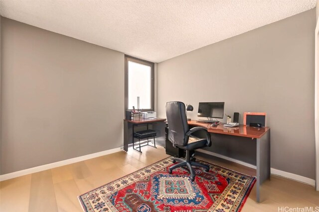 office featuring a textured ceiling, baseboards, and wood finished floors
