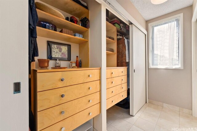 walk in closet with light tile patterned flooring