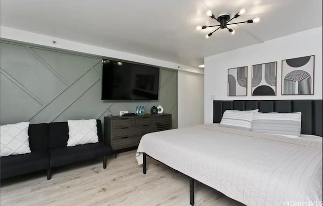 bedroom featuring a chandelier and light wood-style floors